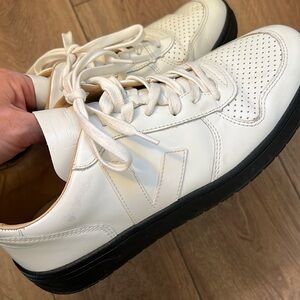 Veja white top low sneakers with black sole.